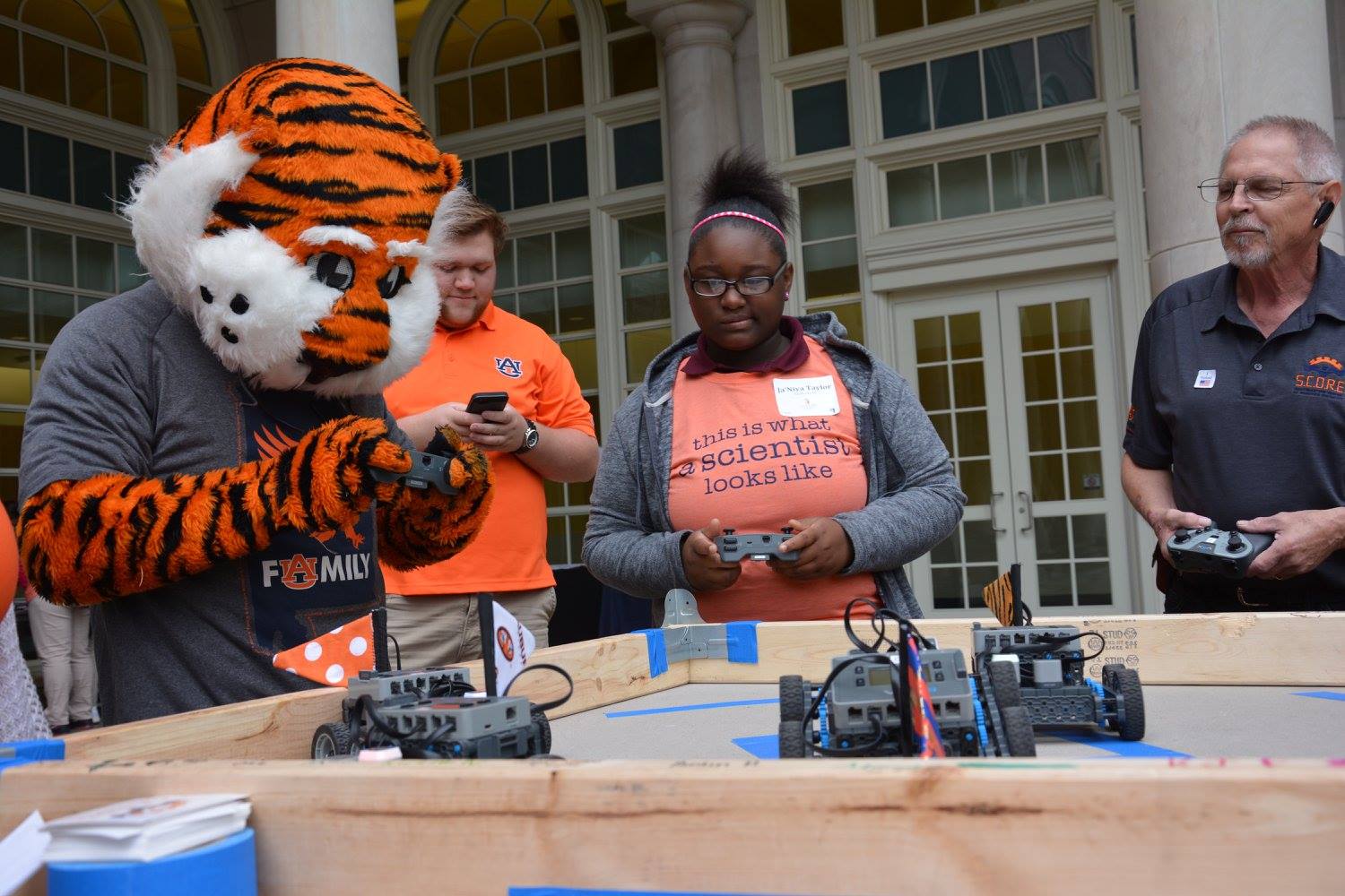Aubie and students driving robots