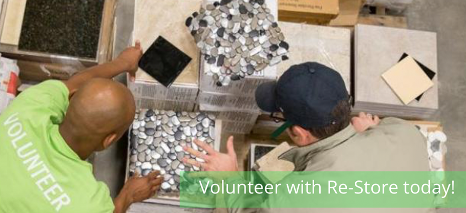 Two men looking at fake rock backsplash tiles. Volunteer with Restore