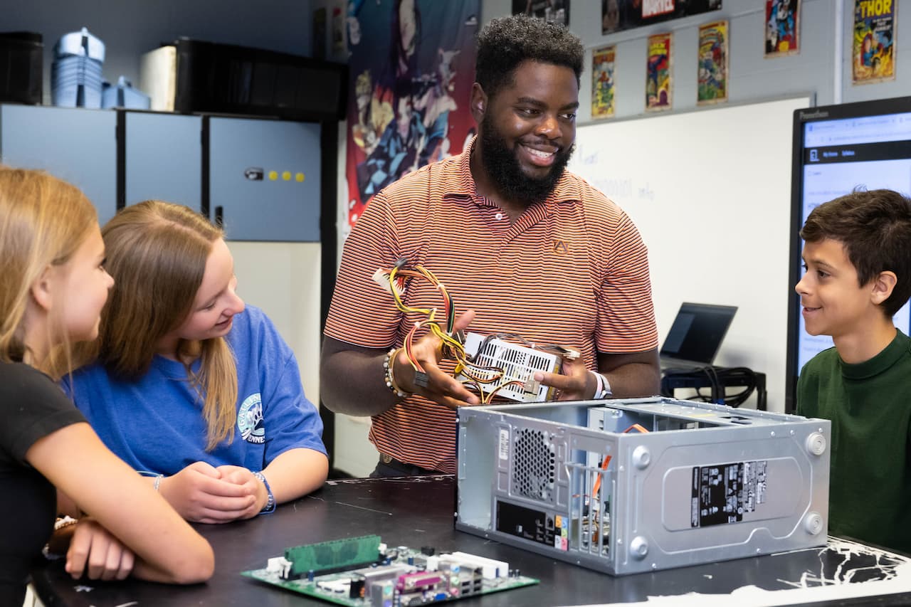 teacher standing with three students