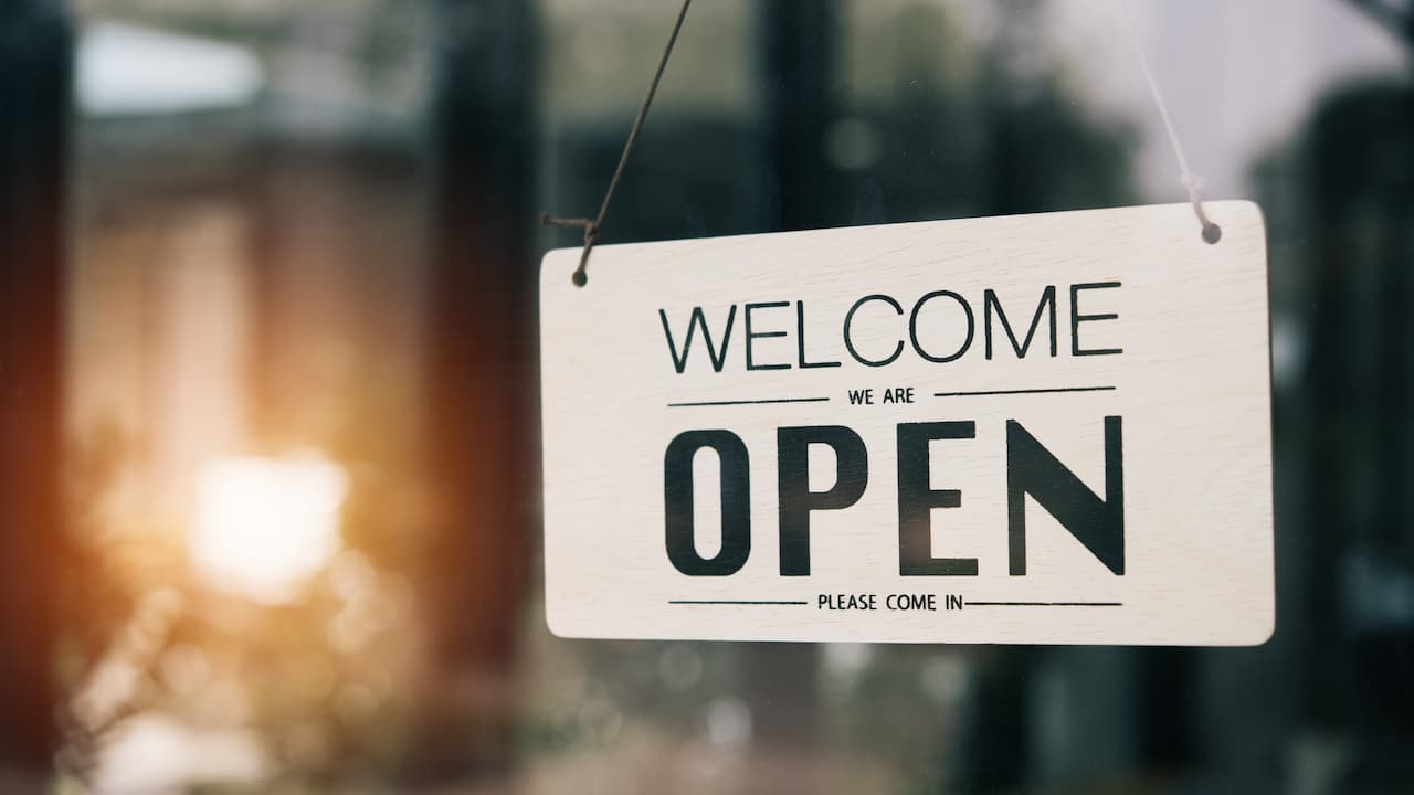 open sign hanging on a glass door