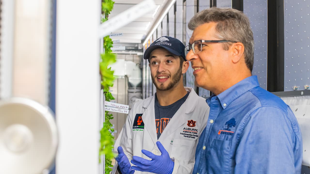 two men in lab coats in an ag lab