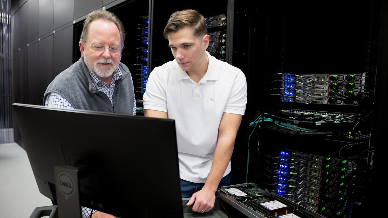 two men looking at a computer