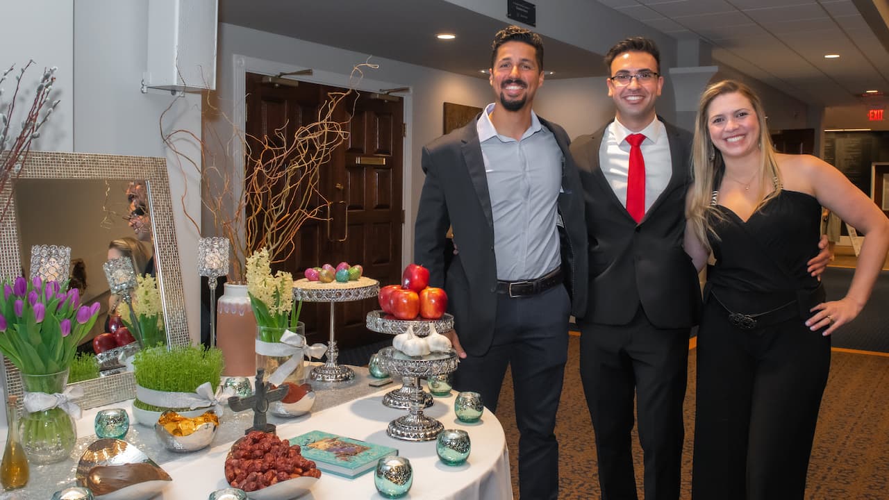 three students in front of a table