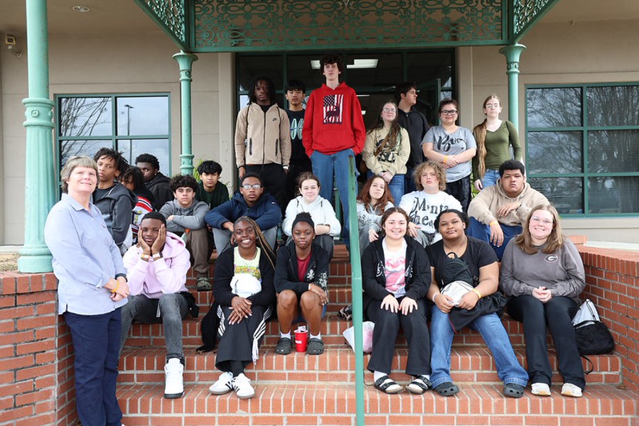 GEAR UP Achieve Region 11 School Liaison Susan Hudspeth poses with a group of students on a staircase on a field trip to Wallace Community College.