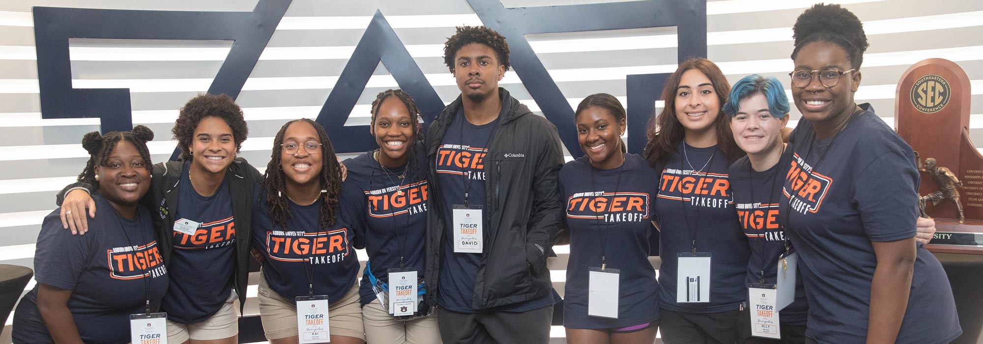 Several students with Tiger Takeoff shirts on pose for a photograph
