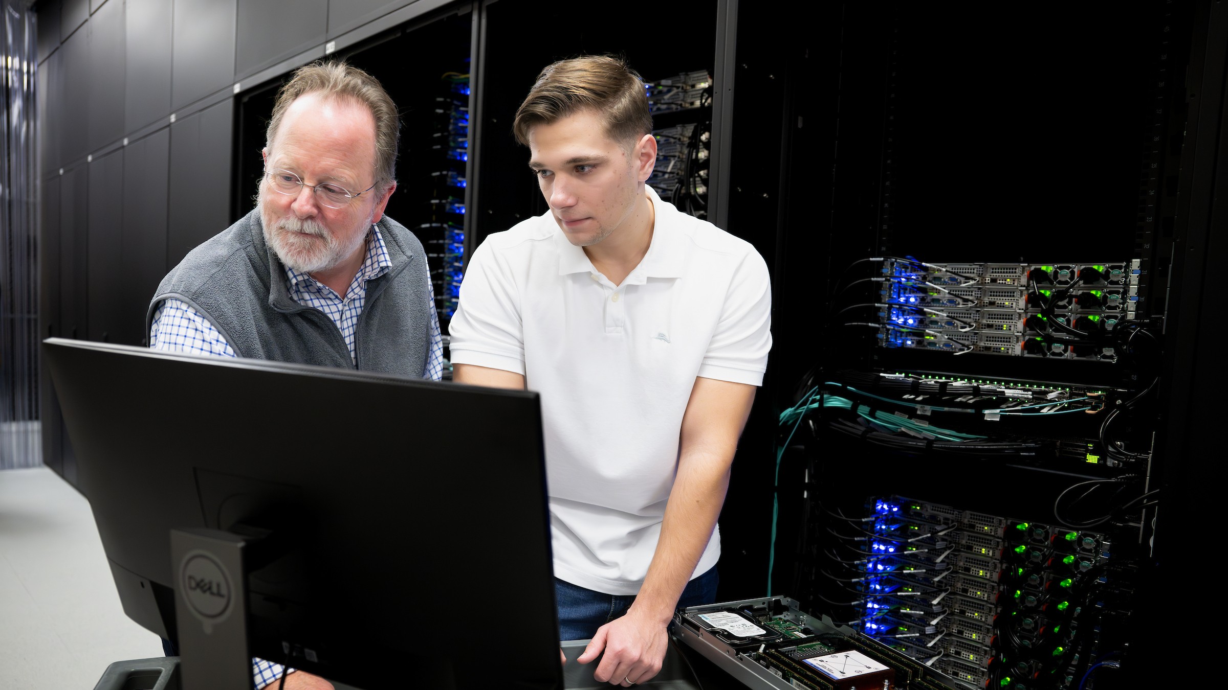 faculty member and student looking at a computer together