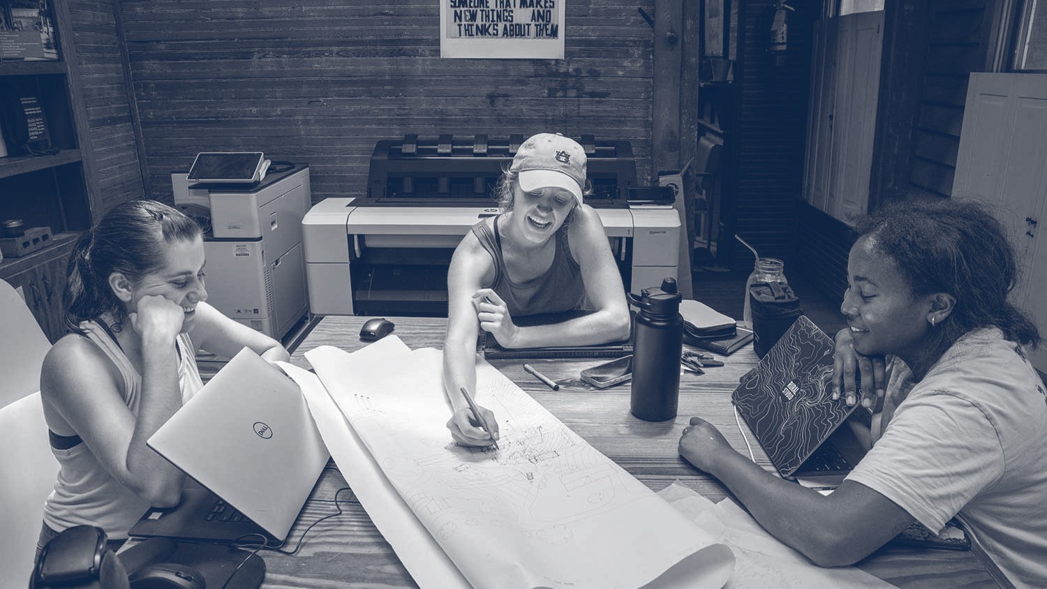 three students working on blueprints