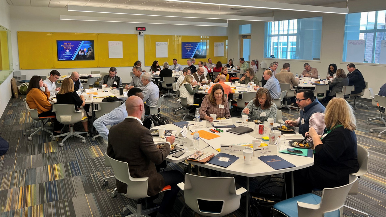 employees sitting around tables in a classroom