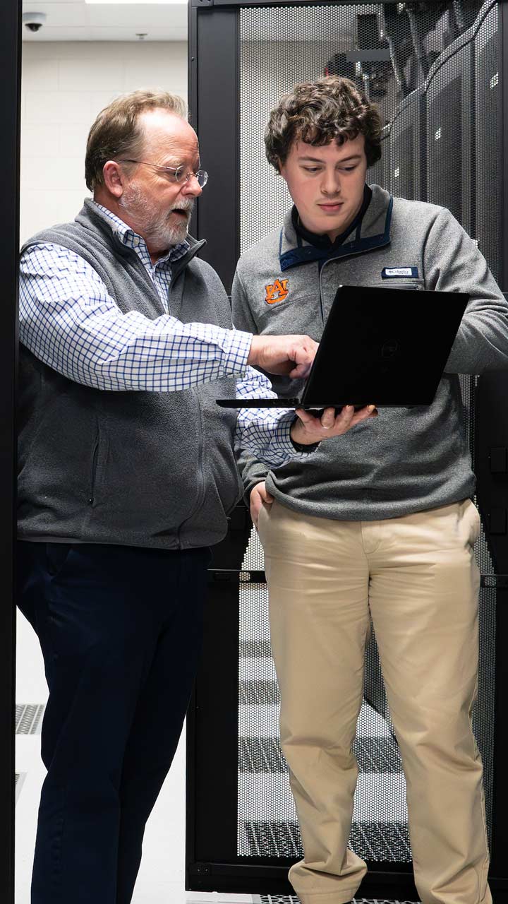 An employee and a student in a server room
