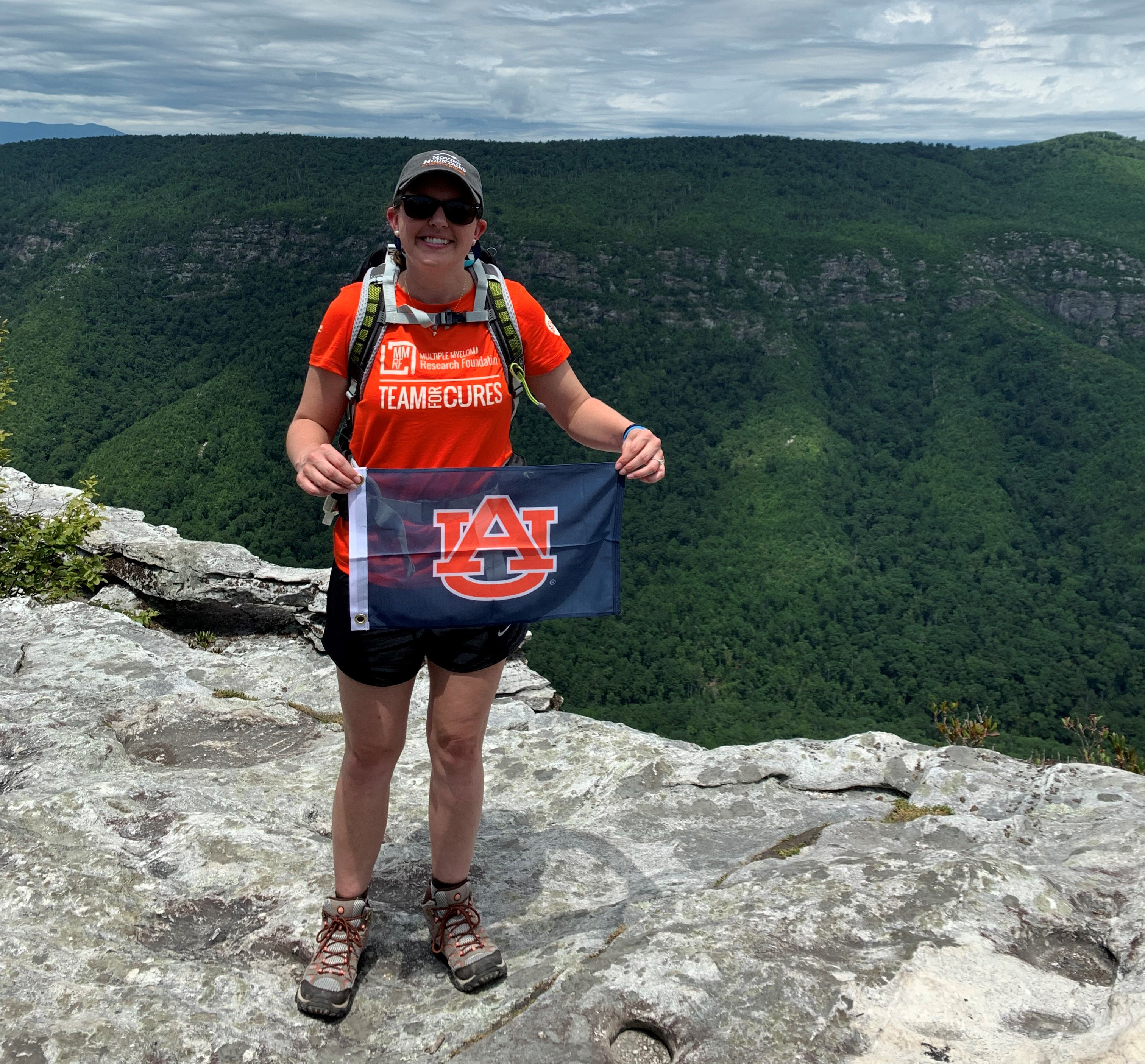 Meredith Powell holds an Auburn University flag in North Carolina. She trained in the Pisgah National Forest to prepare for her journey in Iceland. 