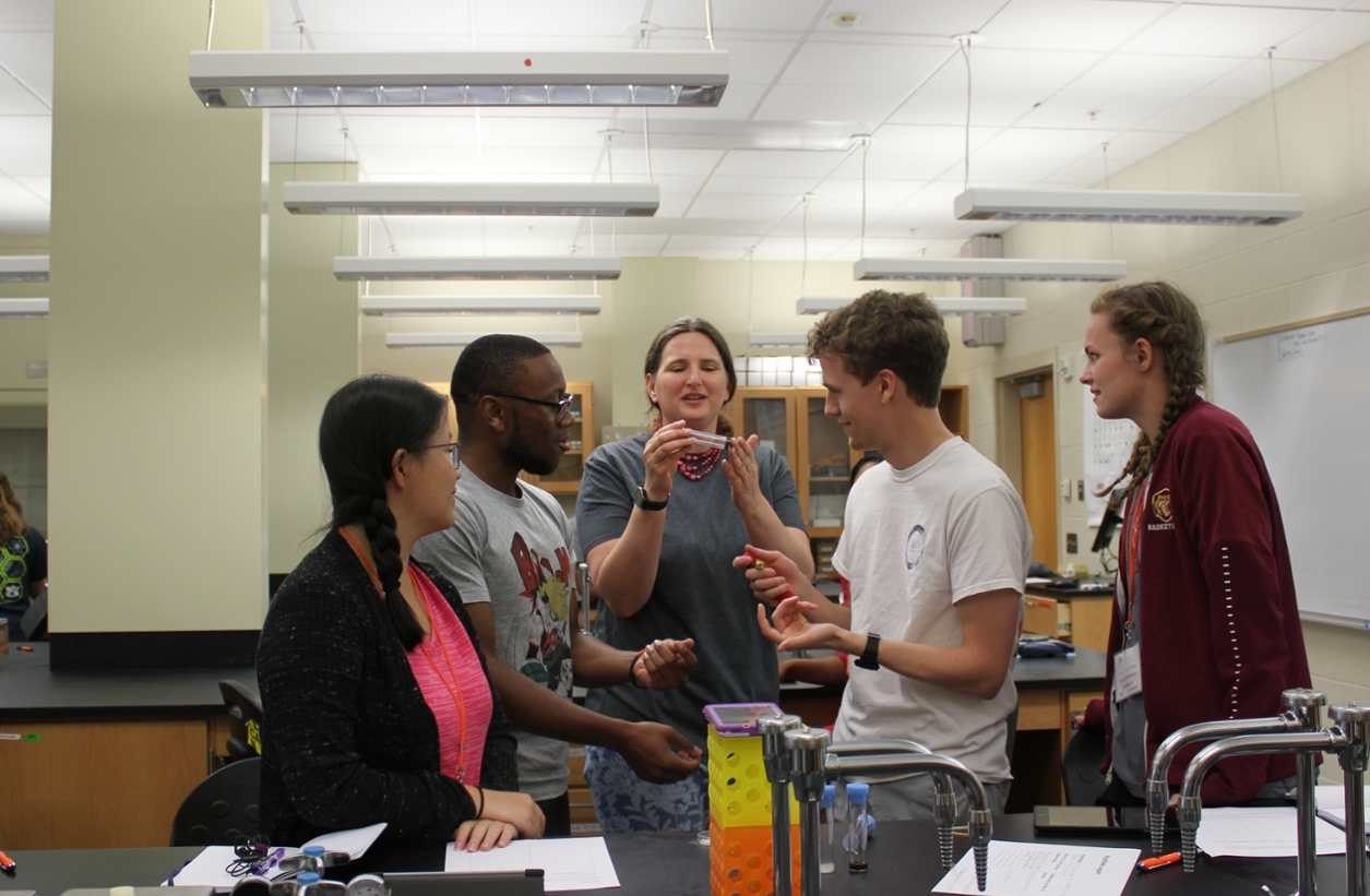 Dr. Graze showing fruit flies to a group of students in the lab