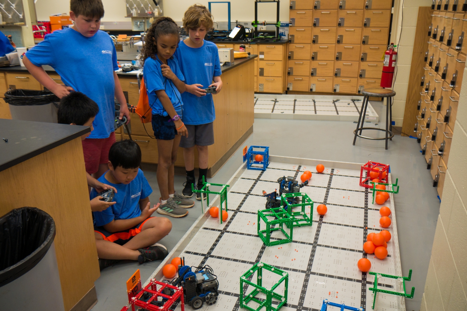 Group of middle school students driving robots on course