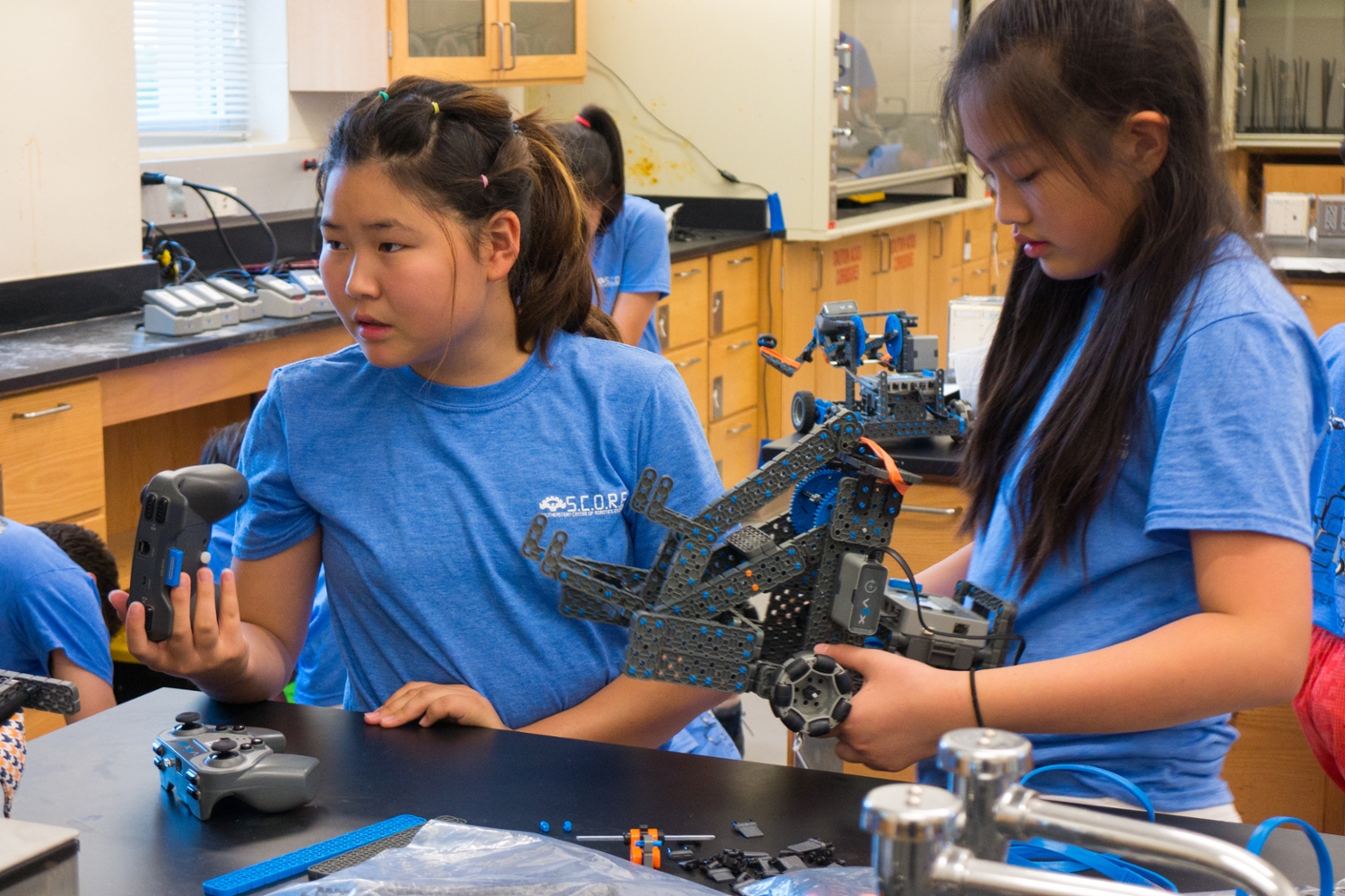 two middle school students working on a VEX robot