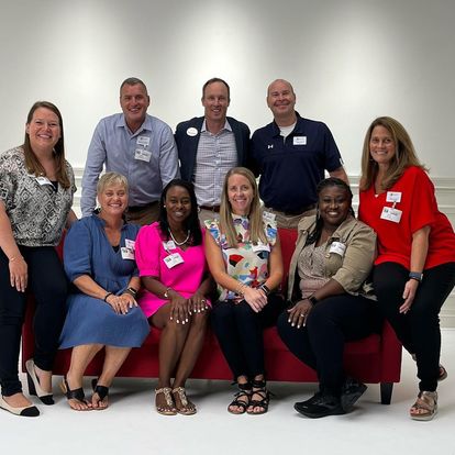 The AMSTI-AU staff, pictured on the notable red couch, recently visited Chick-Fil-A’s corporate office to explore the organization’s culture and leadership philosophy.