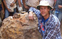 Shawn Wright posing with a large meteorite