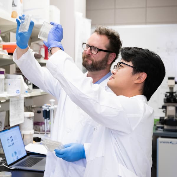 student and faculty member in a lab