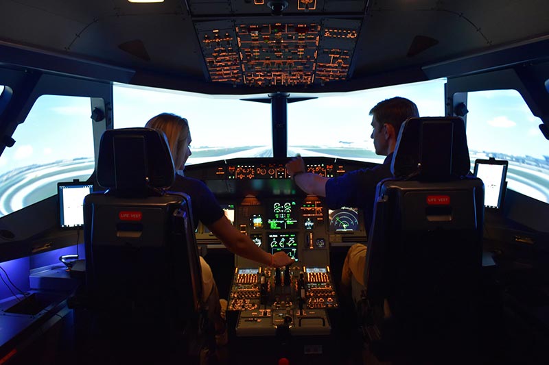 Two students using a flight simulatoro