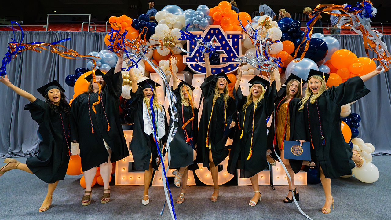 Several graduates celebrating and cheering
