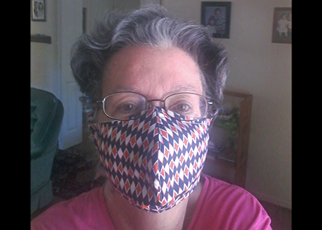 Arlene Heil poses for photo with one of her hand-sewn face masks on.