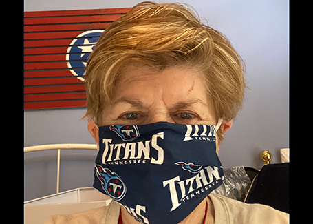 Older woman wears Tennessee Titans fabric face mask.