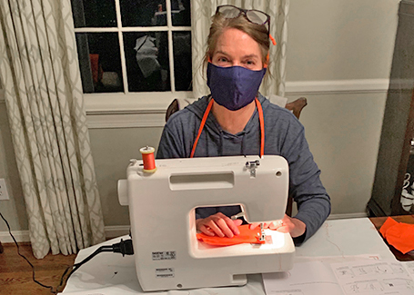 Robin sits at her sewing machine working on making face masks.