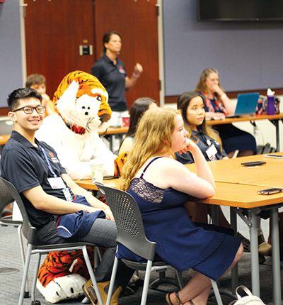 Aubie dons his white lab coat and participates in the classroom portion of pharmacy camp.