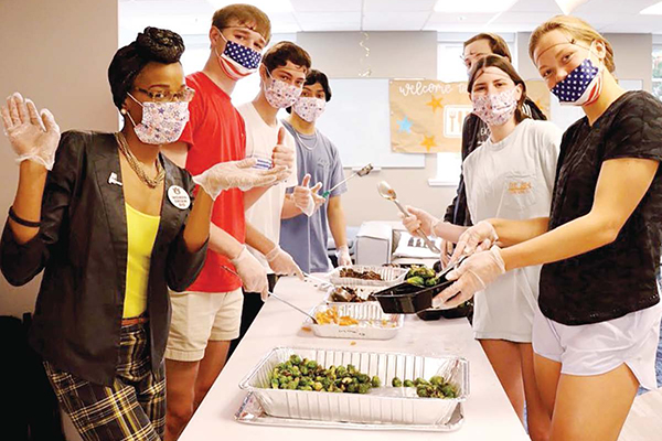 Campus Kitchen co-advisor, Whitney Lee assisting with meal prep during SUST 2000 class visit.