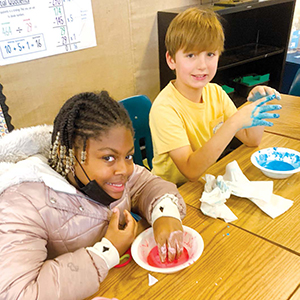 Students at Yarbrough Elementary Schools playing with Oobleck, a material that changes properties based on the forced used with it