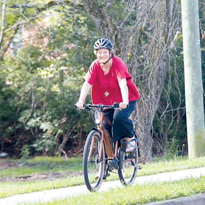 Bishop has gone beyond the workplace to considering sustainability in everyday life. She is pictured riding her energy assist bike.