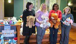 Four women stand for photo holding donated stuffed animals
