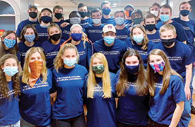 Group photo of Campus Kitchens students wearing dark blue club t-shirts wearing face masks