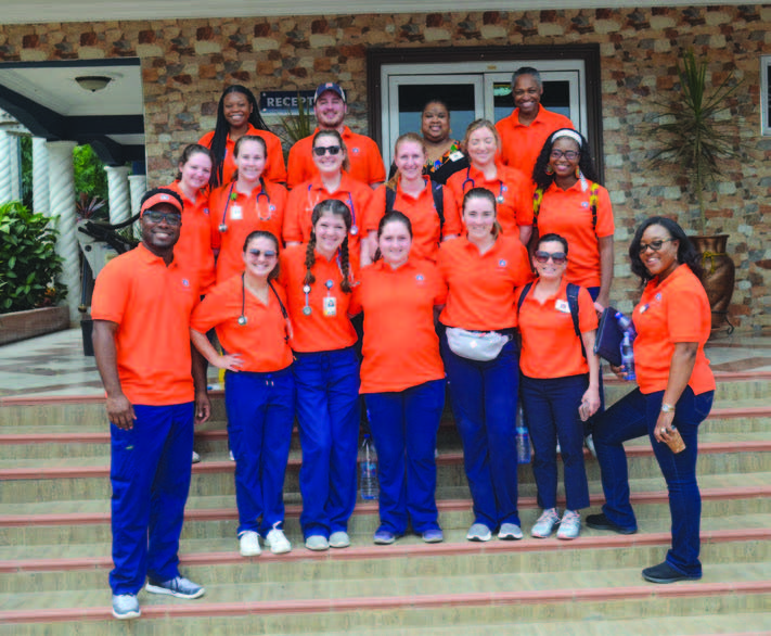 Group of AU Nursing students standing in front of building after mask donation