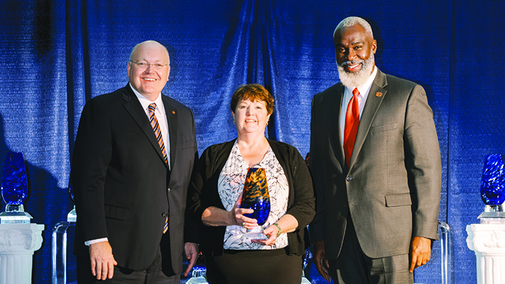 JoEllen Sefton receiving 2024 Award for Excellence in Faculty Outreach pictured with AU President Christoper Roberts and Royrickers Cook.