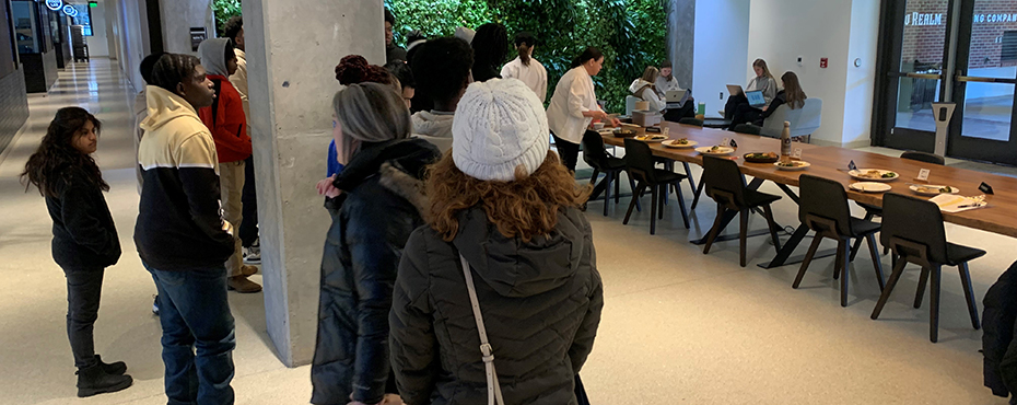 A group of male and female students tour a culinary arts presentation