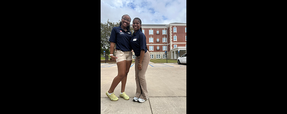 2 female student outreach ambassadors stand for a photo at the conclusion of a campus tour.