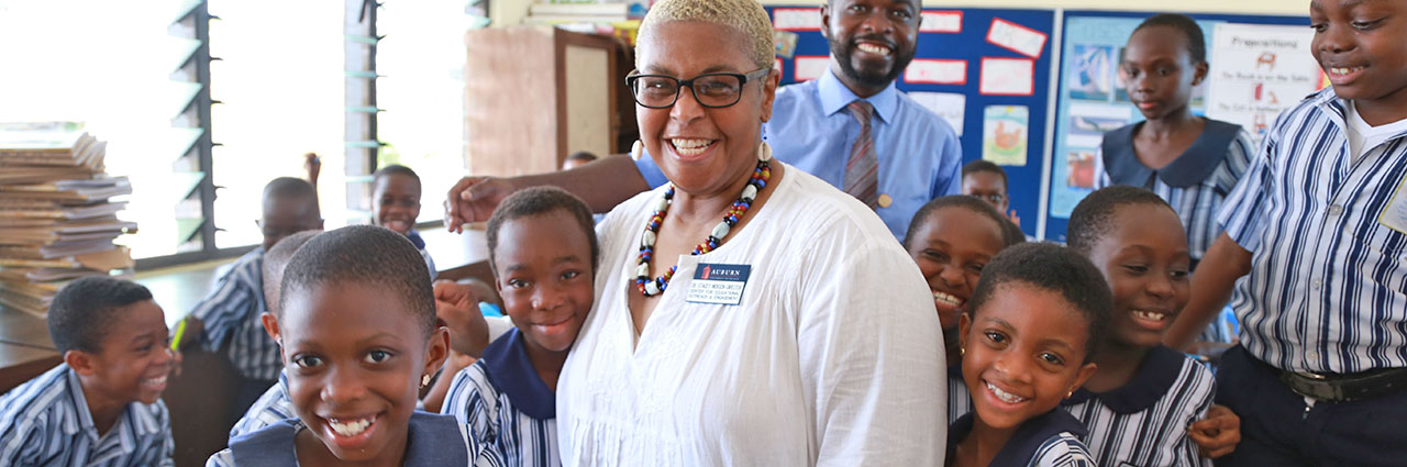 CEOE Director, Stacey Nickson poses for photo with african students in Ghana primary school.