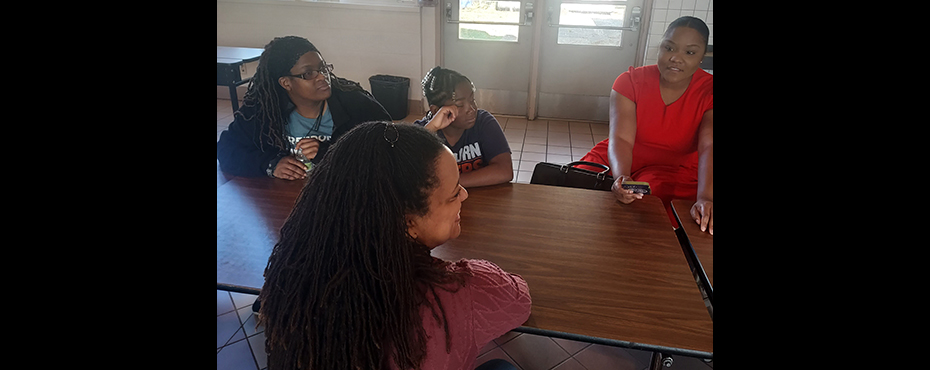 A small group of female students and parents have a discussion in a classroom