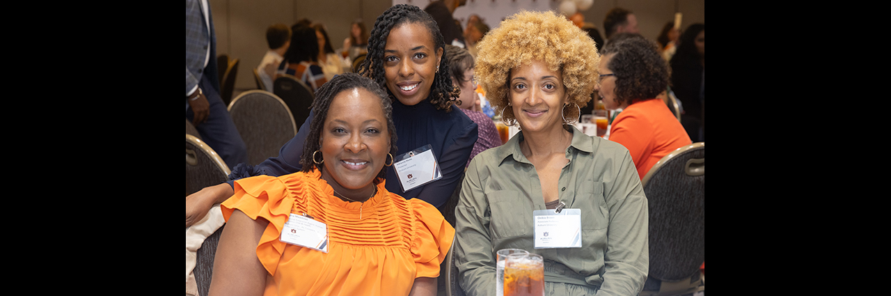 Three female event attendees sitting around a table