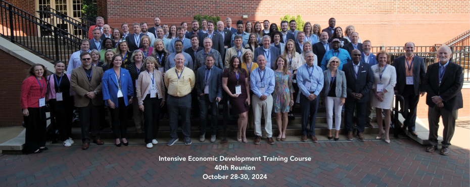 Photo of Intensive 40 Year Reunion participants and text 'Intensive Economic Development Training Course 40th Reunion, October 28-30, 2024.'