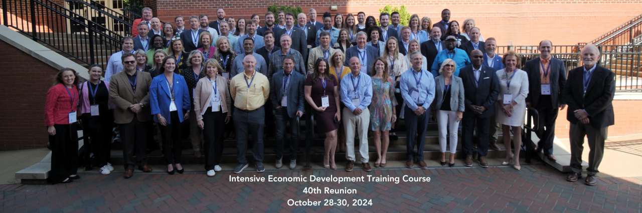 Photo of Intensive 40 Year Reunion participants and text 'Intensive Economic Development Training Course 40th Reunion, October 28-30, 2024.'