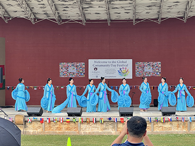 Asian women on stage wearing native dresses