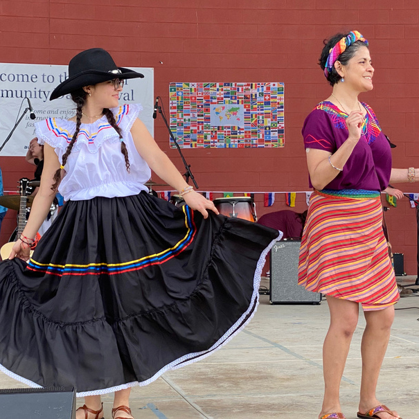 Two women dancing on stage wearing cultural attire