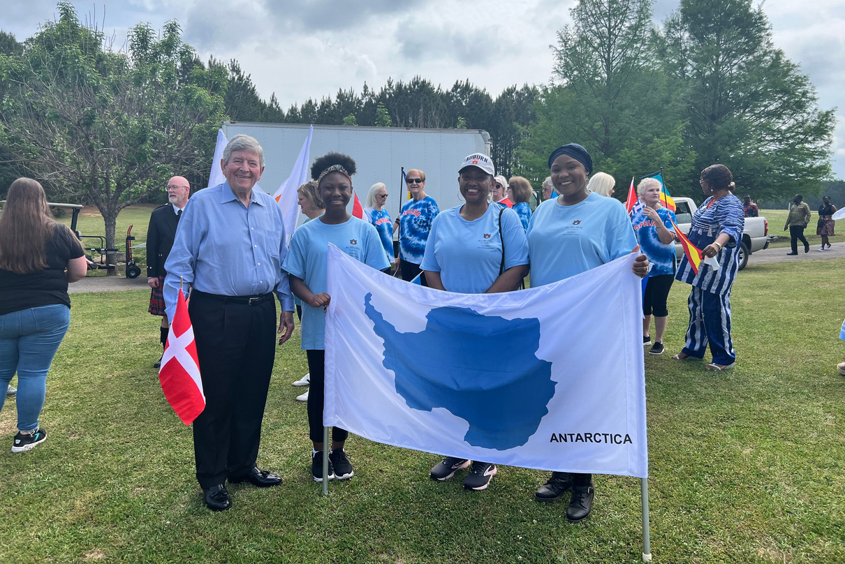 Participants standing behind a flag of Antartica