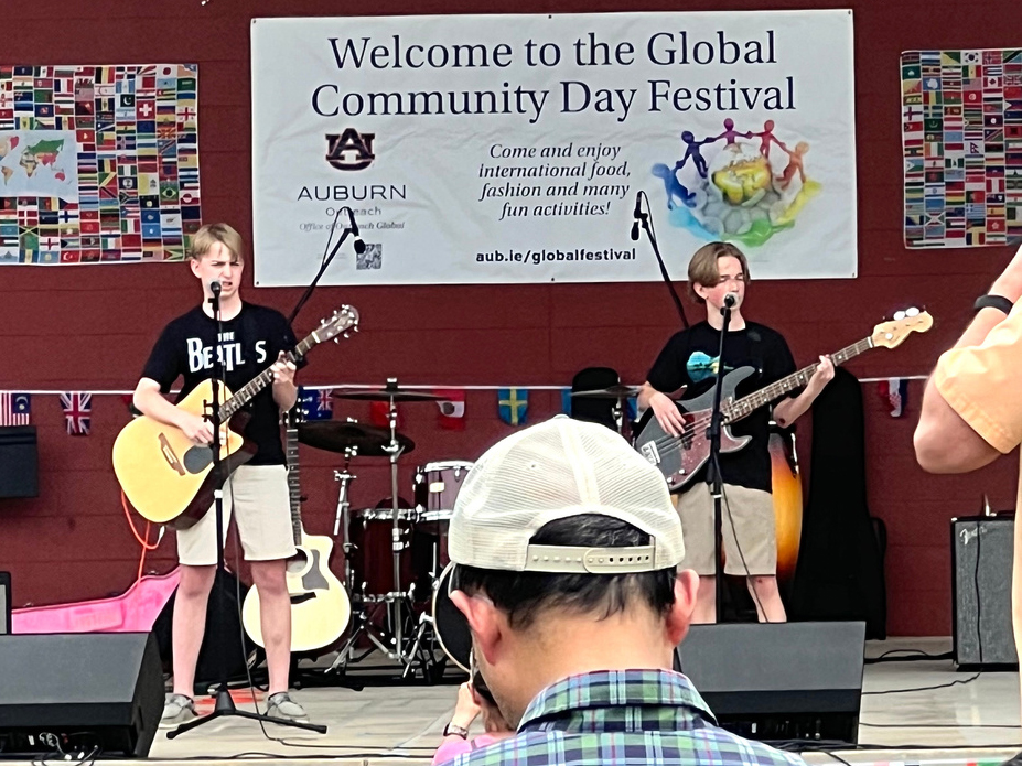 two young males on stage playing guitars