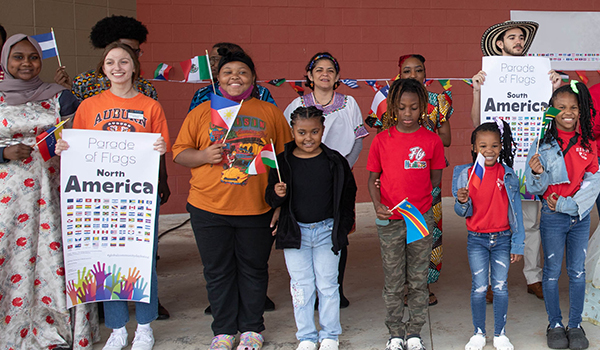 Kids holding flags of different countries during global community day