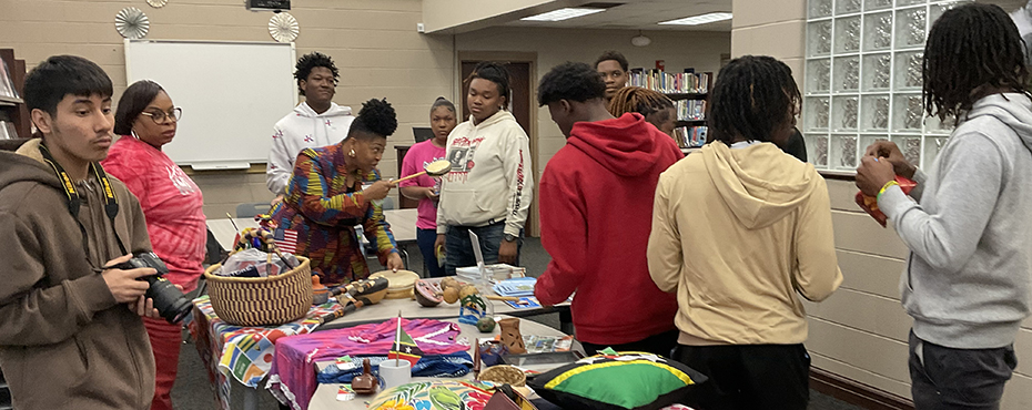 Students lookings at arts and crafts on a table.