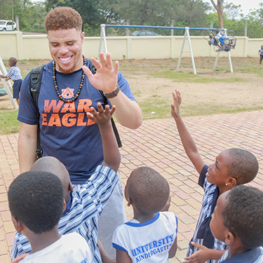 An Auburn student high-fives Ghanian students during Spring Break trip to Ghana, Africa