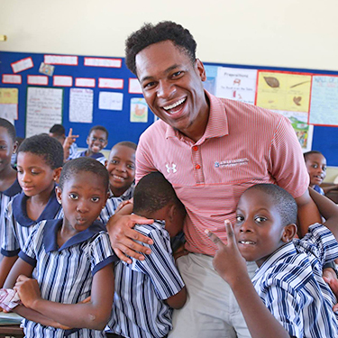 An Auburn student poses with Ghanian students during Spring Break trip to Ghana, Africa