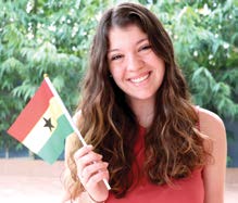 Hannah Black holding small ghanian flag and smiling for photo.