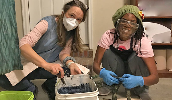 Dr. Chris Schnittka and Dr. Chinyere Knight dyeing with indigo at a workshop.